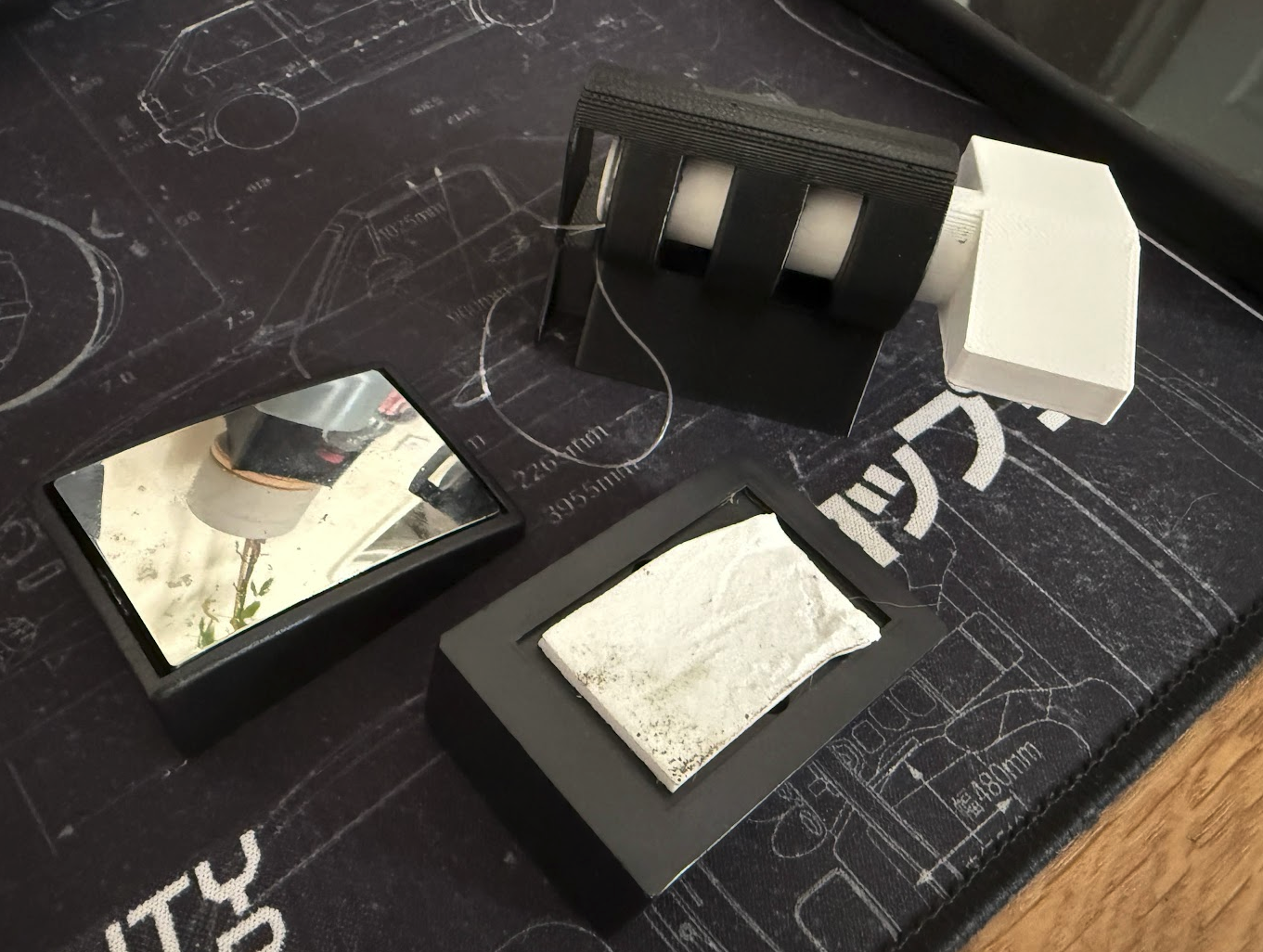Image of the printed 3D model from the article, showing two removed blind spot mirrors beside the tool